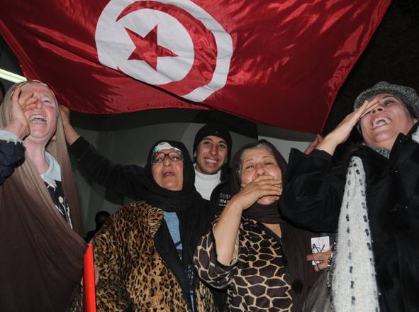 Tunisians celebrate after announcement of dissolution of the former ruling party the RCD